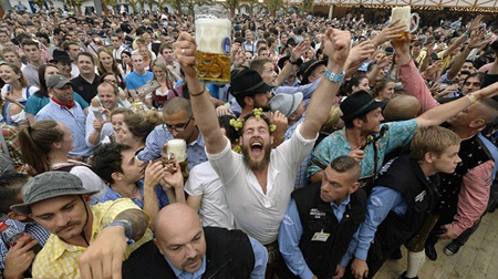 Người tham dự giơ cao những cốc bia đầu tiên trong lễ hội kéo dài 16 ngày ở thành phố Munich, Đức.